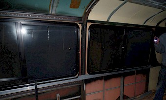 Bus windows have been removed and replaced with insulated glass sliders.